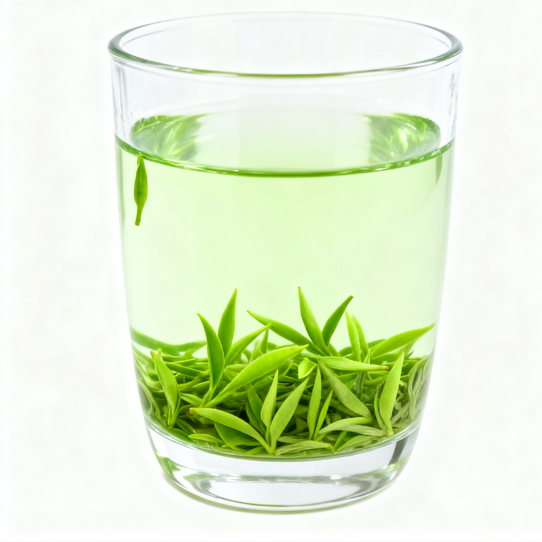 Clear glass filled with fresh green tea leaves against a white background.
