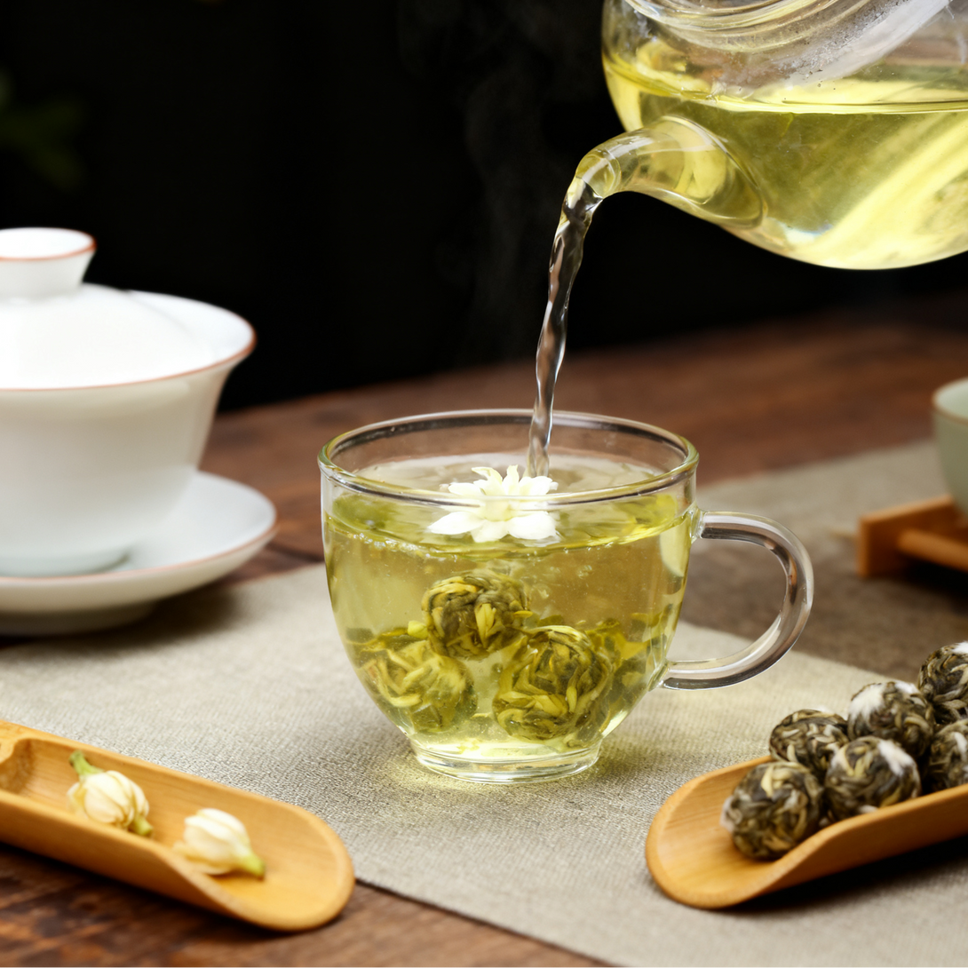 A glass teapot pouring tea into a clear glass cup, set on a wooden table with a calm and serene atmosphere.