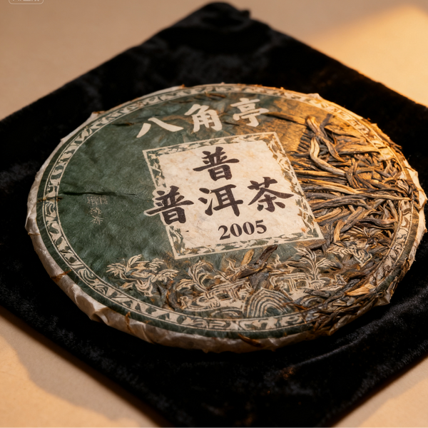 2005 Bajiao Ting Pu-erh tea cake on black velvet cloth, showing detailed tea leaves under warm light
