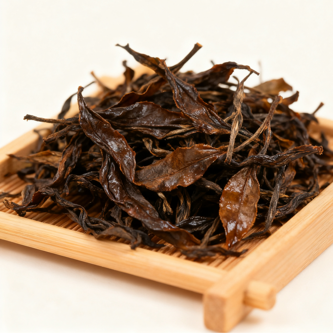 A close-up of dried tea leaves arranged on a bamboo tray.
